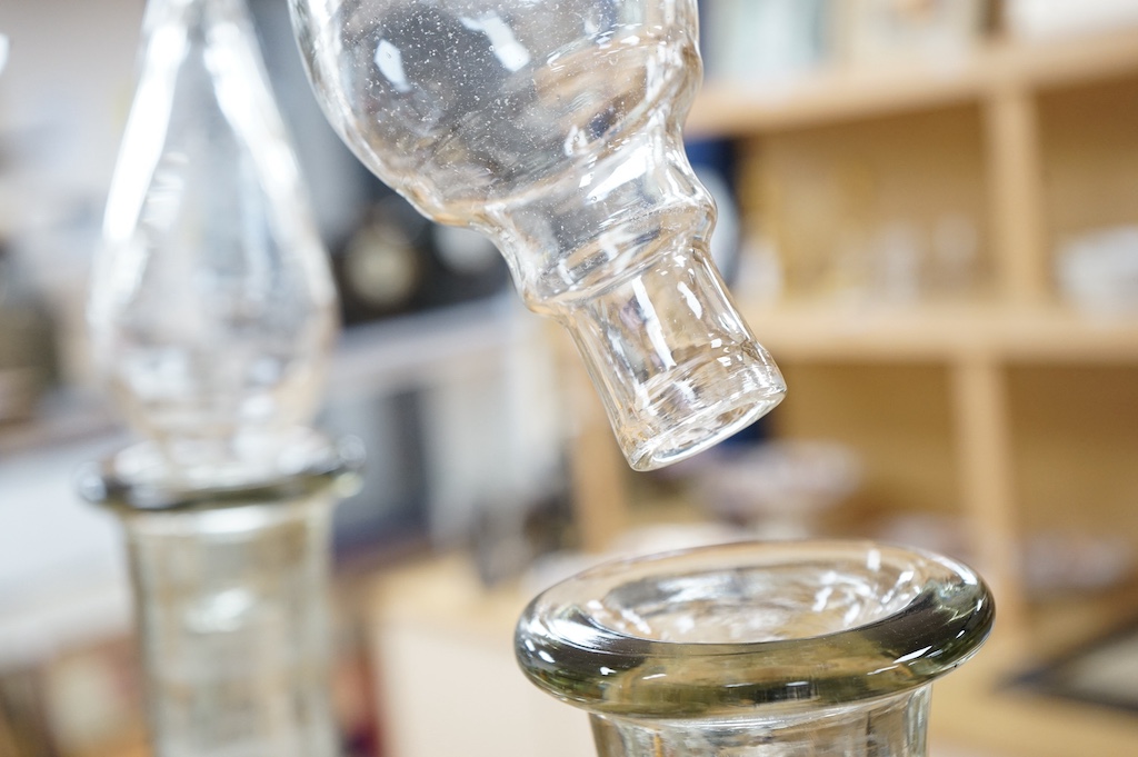A pair of clear glass chemist's carboys and stoppers, 81cm high including stoppers. Condition - good